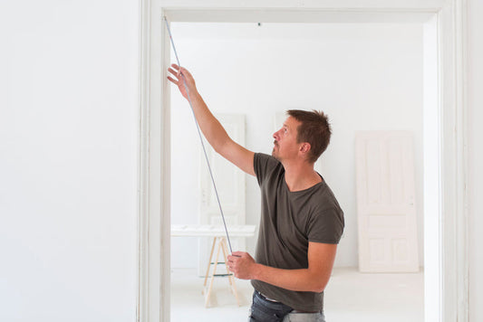 A man measuring a door frame