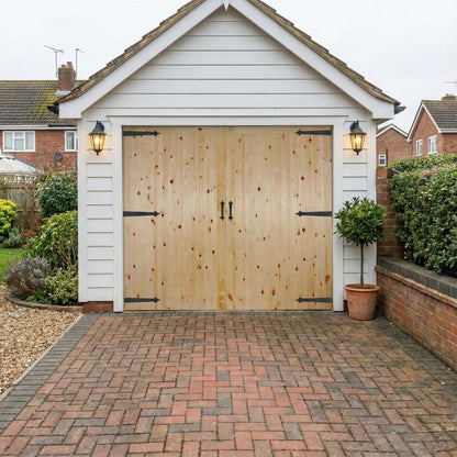 Wooden garage door on a house with a brick driveway and garden.